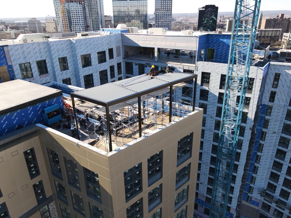 High-rise rooftop louvered roof installation with tower crane