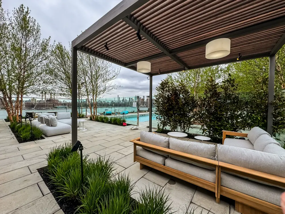 Rooftop lounge with pergola, pool, and skyline